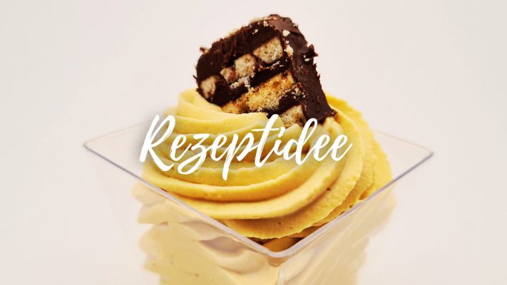 Die Pfunds Karamell-Quark-Creme ist ein einem kleinen Becher angerichtet und das Topping ein Stück vom Gebäck "kalter Hund"